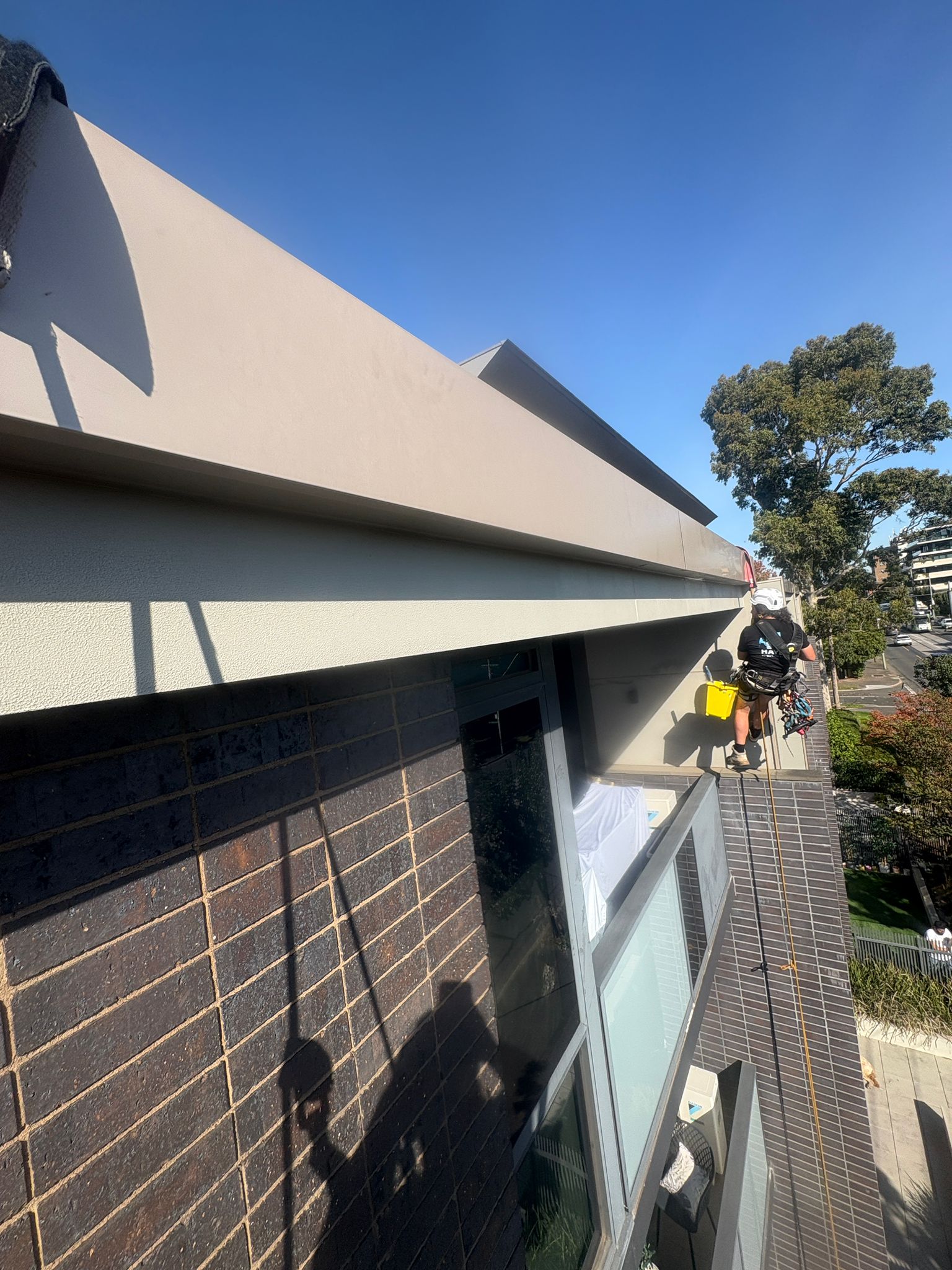 Rope access painter on Melbourne strata building slab edge painting