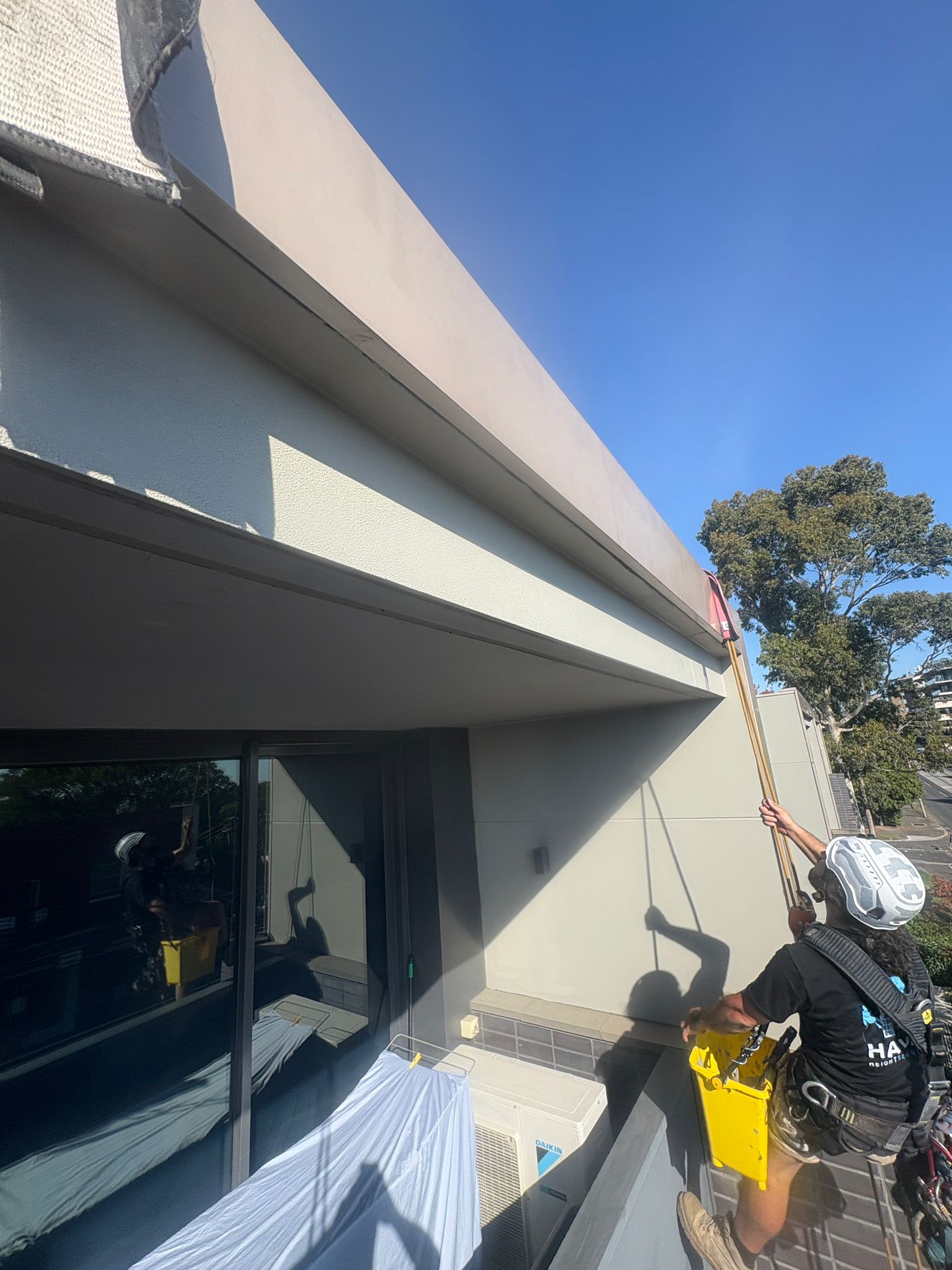 Rope access painting Melbourne — technician working on high-rise facade without scaffolding